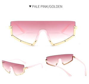 Detail of oversized shield sunglasses with pale pink gradient lenses and golden frame