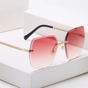 Rimless oversized square sunglasses with pink gradient lenses and golden chain arms