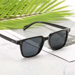 Classic retro square sunglasses with black frame and silver rivets on a summer background