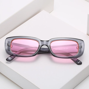 Fashionable rectangle sunglasses with grey translucent frames and pink lenses on a white pedestal