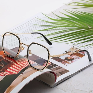 Lunettes de soleil carrées classiques avec monture métal noir et or sur magazine