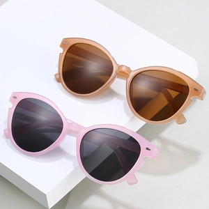 Cat-Eye-Sonnenbrille mit rosa und bernsteinfarbenen Rahmen und dunklen Gläsern