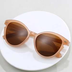 Cat-Eye-Sonnenbrille mit beigem Rahmen und braunen Gläsern auf Steinsockel