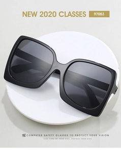 Top view of black oversized square sunglasses on a minimalist white stone tray