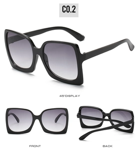 Detail view of large square black sunglasses with purple gradient lenses and 45 degree angle