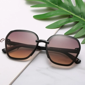 Chic black oversized square sunglasses with brown gradient lenses on marble background