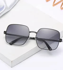 Detail of square oversized sunglasses with black metal chain temples and gradient lenses