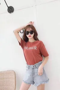 Detail of red-brown cotton T-shirt with white RUBER text and frayed denim shorts