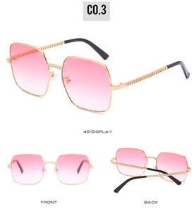 Detail view of retro square oversized sunglasses with gold chain temples and pink lenses