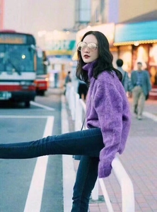 Close-up of oversized purple knit sweater with high neck and soft plush texture