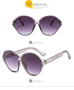 Detailed view of oversized oval sunglasses with transparent grey frames and gradient lenses