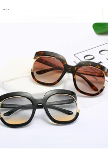 Detail of oversized sunglasses with gold metal trim in tortoiseshell and black finish