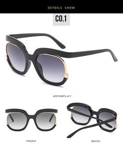 Detail view of large frame sunglasses with black frames and gold metal edging accents