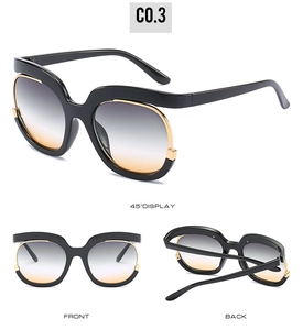 Detail view of oversized sunglasses featuring gradient lenses and gold metal accents