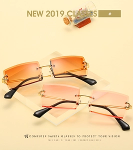 Detail of rimless rectangle sunglasses with pink and orange gradient lenses and gold metal frames