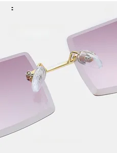 Detail view of the frameless gradient sunglasses showing golden bridge and soft nose pads