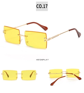 Close-up of rimless square sunglasses with yellow lenses and gold metal frames