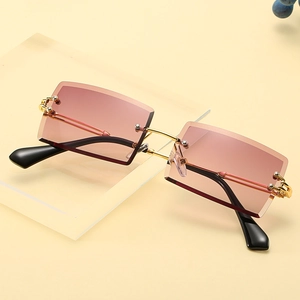 Frameless square sunglasses with gradient brown lenses and gold metal temples on a display