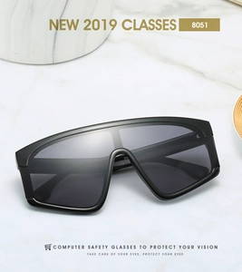 Macro detail of 8051 black oversized one-piece sunglasses on white marble surface