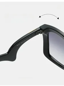 Detail shot of sturdy metal hinge and size specifications on black oversized sunglasses