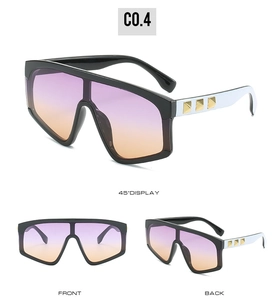Detail view of fashion sunglasses with purple gradient lenses and gold pyramid rivets