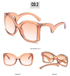 Detail of orange acetate sunglasses featuring wavy temples and metal triangle accents