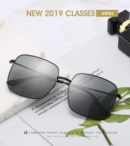 Modern black square metal sunglasses with blue light blocking lenses on a marble surface