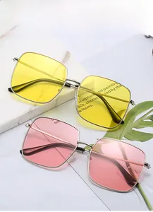 Close-up of retro square metal sunglasses with yellow and pink translucent lenses