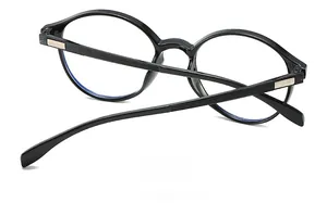 Detail view of black round frame glasses with golden hinges and blue light lenses