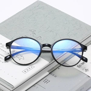 Retro black round anti-blue light glasses resting on books for eye protection and style