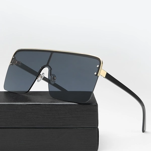 Oversized square sunglasses with gradient lenses and gold metal trim on a display box