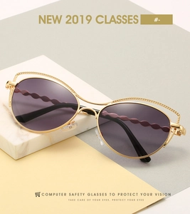 Détail de lunettes de soleil œil de chat avec chaîne dorée et verres teintés violets