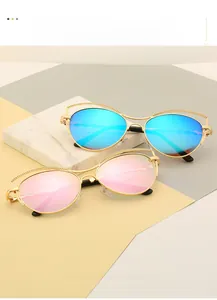 Détail des lunettes œil-de-chat avec monture dorée et décor de chaîne sur marbre
