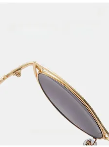 Détail de la charnière métallique robuste sur lunettes de soleil œil de chat dorées