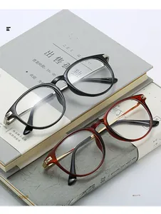 Retro round glasses frames in black and tortoise shell finish displayed on books