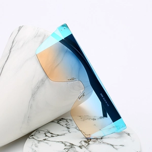 Lunettes de soleil bouclier sans monture avec verres dégradés bleu orange sur marbre