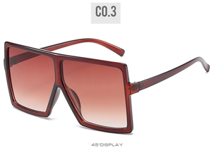 Detail view of large square oversized sunglasses in dark red brown with gradient lenses