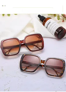 Close-up of square sunglasses with gold triangular hollow metal details on frame