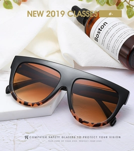 Flat top oversized sunglasses featuring a black frame and tortoiseshell pattern temples
