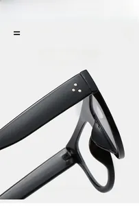 Detail view of black acetate frame showing metallic triple rivet hinges and glossy finish