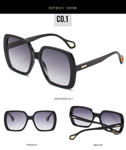 Detail showing oversized black square sunglasses with gold metal geometric accents