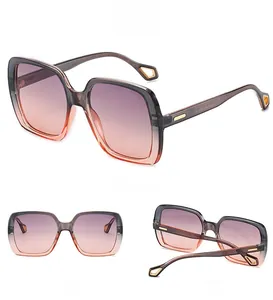 Detail view of square gradient sunglasses with gold geometric accents and transparent frame