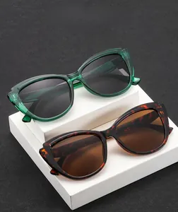 Detail of oversized irregular sunglasses in translucent green and tortoiseshell texture