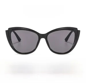 Detail showing oversized black cat-eye sunglasses with UV protection and polarized lenses