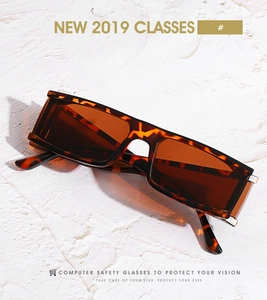 Détail de lunettes de soleil rectangulaires en écaille sur une surface en pierre