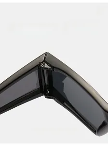 Vue détaillée de la charnière en métal robuste sur lunettes de soleil carrées noires