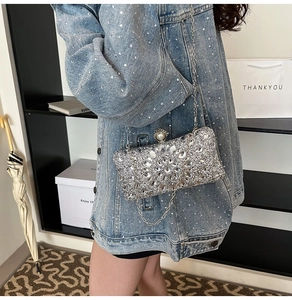 Close-up of silver rhinestone evening bag with pearl clasp and metal chain strap
