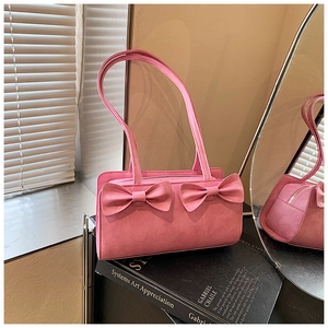 Macro detail of pink leather handbag featuring decorative bows and silver zipper closure
