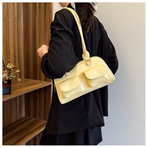 Close-up of pale yellow Boston bag with double pockets and slim straps in casual style