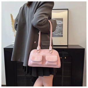 Detail of soft pink bowling bag featuring front pockets and elegant gold hardware loops